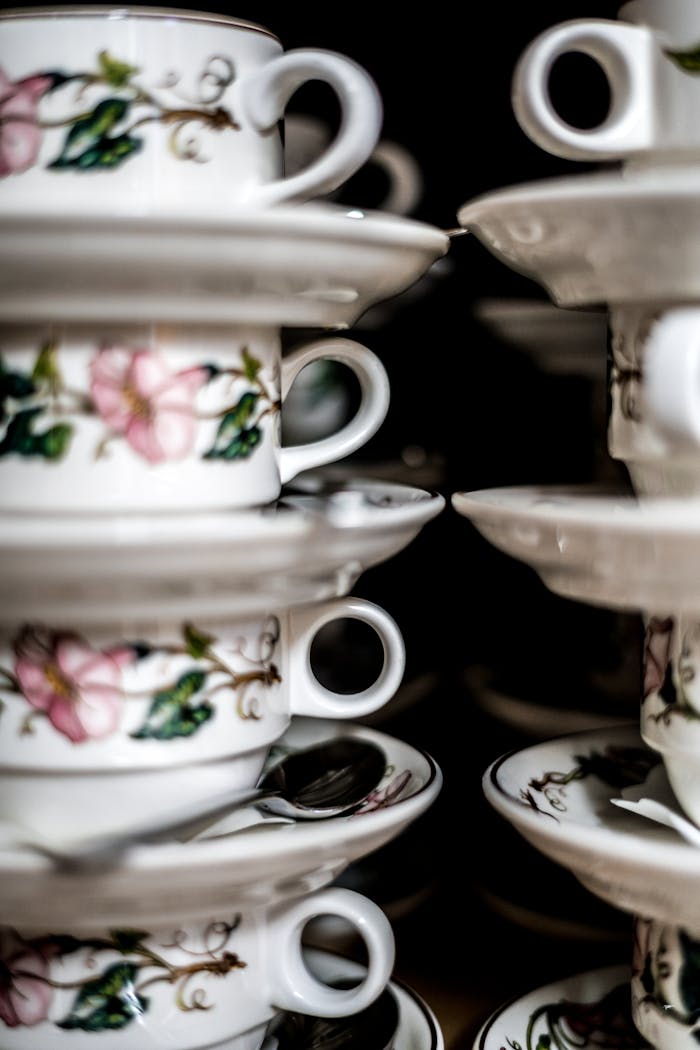 A collection of stacked floral ceramic teacups, showcasing intricate porcelain designs.